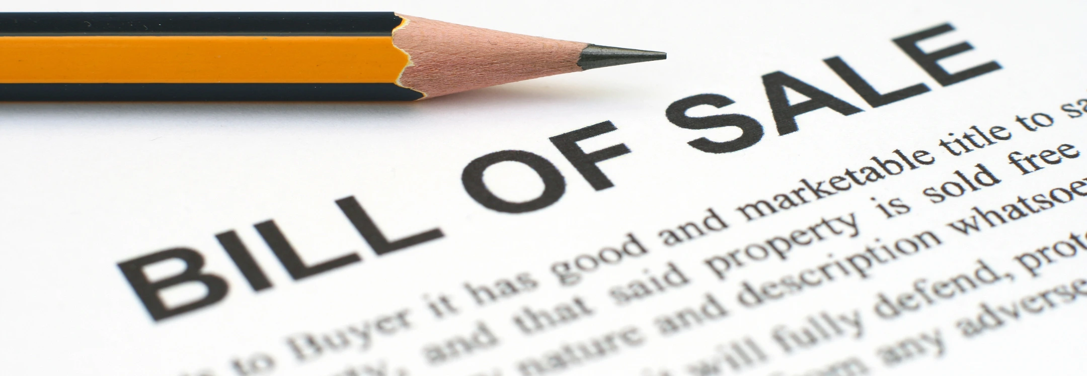 Close-up of a Bill of Sale document with a pencil on top, representing property transfer or legal sale agreement.
