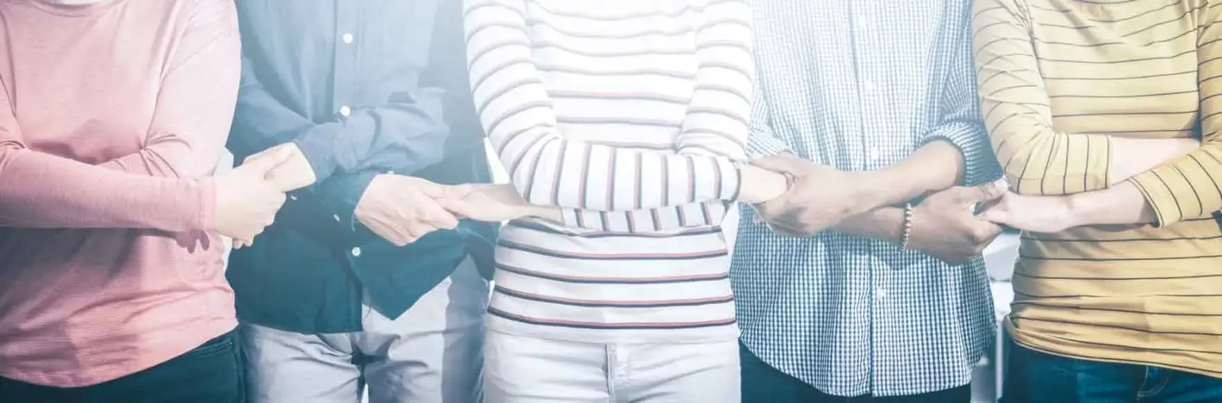 Group of people holding hands related to family and business legal needs in the US